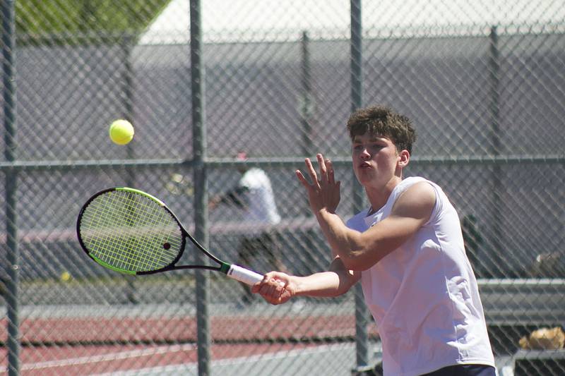 Oswego East senior A.J. Johnson sends the ball flying across the court during boys' conference tennis May 26 at Plainfield North High School.