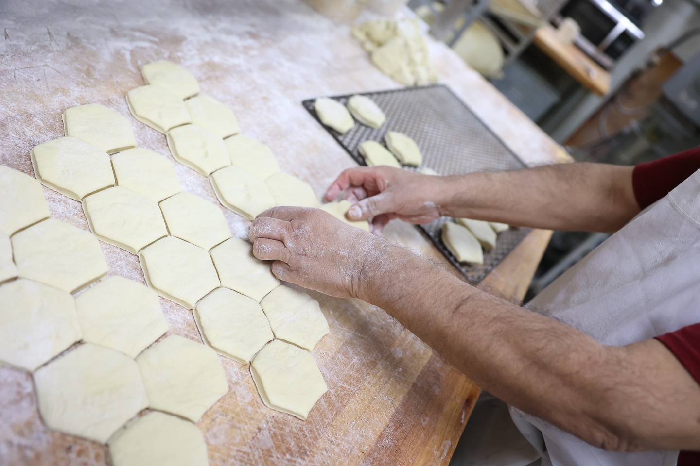 Jesse Barrera preps a tray of paczki doughnuts. Donut Den has over 300 orders for the popular Polish doughnut. Monday, Feb. 28, 2022, in Joliet.