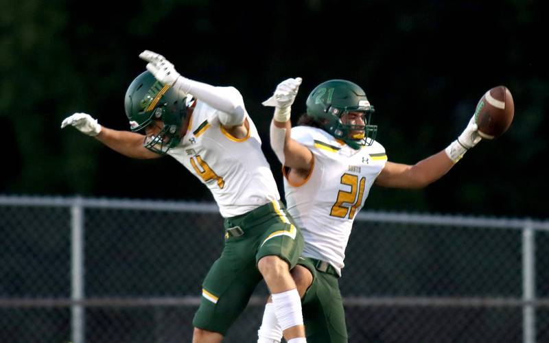 Crystal Lake South’s Nolan Gorken, left, and Michael Prokos, right, celebrate a Prokos touchdown at Cary-Grove High School Friday night.