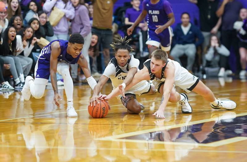 Kaneland’s Troyer Carlson (right) and Isaiah Gipson (center) dives for a lose ball against Plano’s Alijah Johnson (left) late in the 4th quarter of play during a championship game of the 60th annual Plano Christmas Classic Basketball Tournament at Plano High School on Saturday, Dec 30, 2023.