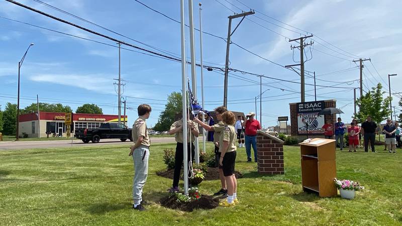 Scouts from DeKalb Scout Troop 33 hoist police and fire flags at the new first responders memorial outside Isaac Executive Suites, 2675 Sycamore Road, DeKalb, during a dedication ceremony held Sunday, May 19, 2024. The memorial was unveiled at the close of National Police Week.
