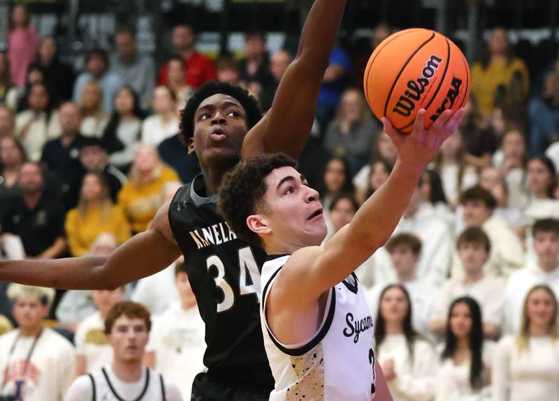 Sycamore's Marcus Johnson tries to shoot the ball past Kaneland's Jeffrey Hassan during their game Friday, Jan. 9, 2025, at Sycamore High School.