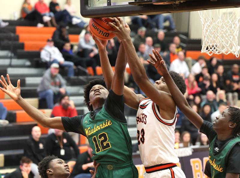 DeKalb’s Davon Grant and Waubonsie Valley's Tyreek Coleman go after a rebound during their game Friday, Dec. 15, 2023, at DeKalb High School.