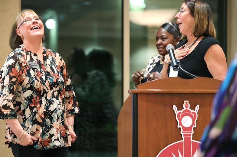 Past Athena Award recipients Jennifer Groce (right) and LaCretia Konan (middle) surprise Rosalie Williams from the DeKalb Chamber of Commerce Tuesday, Oct. 18, 2022, with an honorary award for all she's contributed to the Athena Awards during the Athena and Women of Accomplishment Award reception at the Barsema Alumni and Visitors Center at Northern Illinois University in DeKalb.