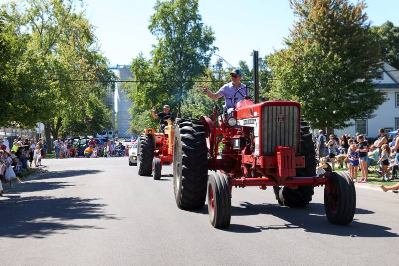 Tractor drivers wave to the crowd as they participate in the Grand Parade during the 104th annual Herscher Labor Day Celebration on Monday, Sept. 1, 2025.