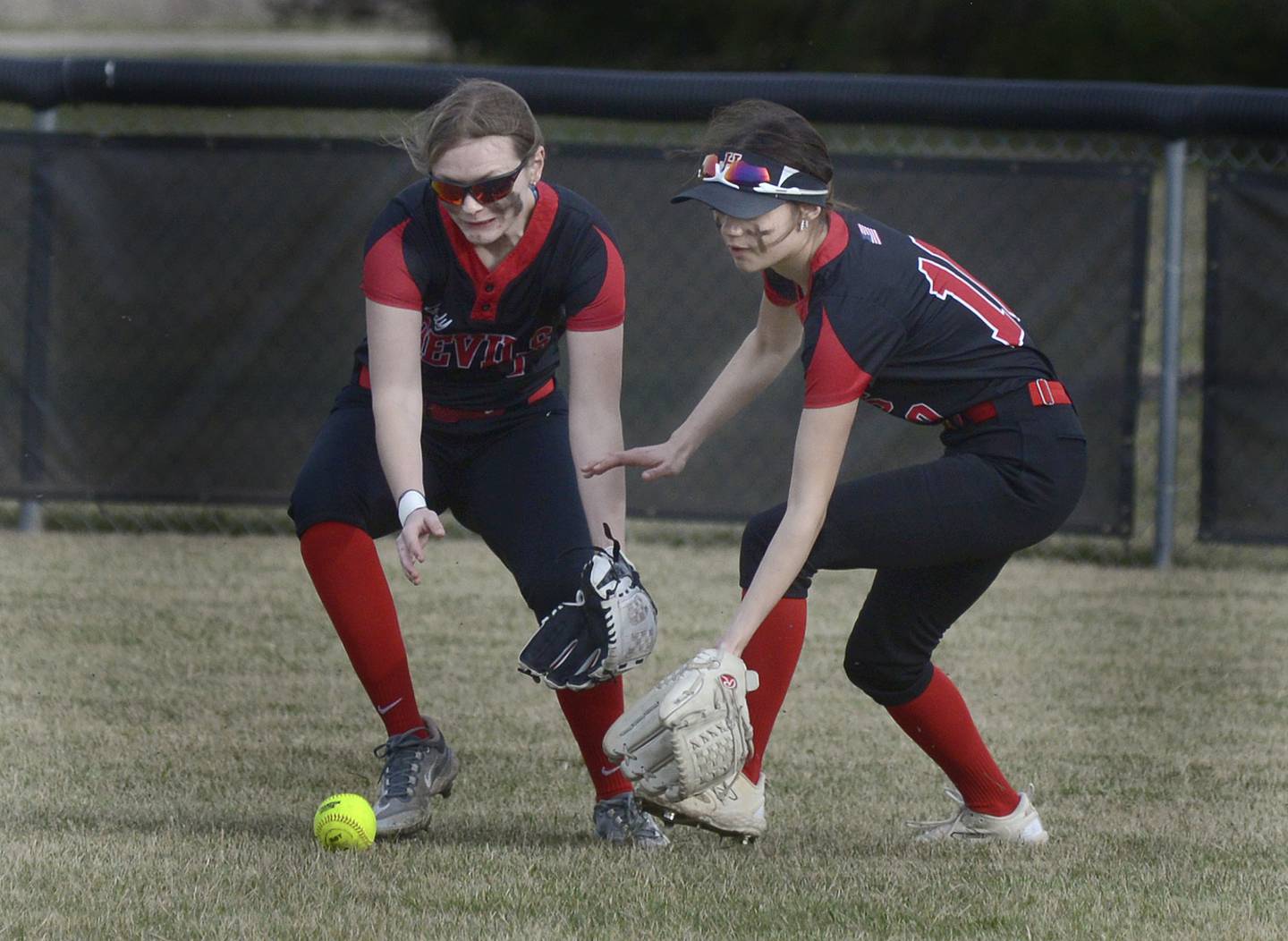 Hall’s Mya McLaughlin (left) and Haven Rossi converge in right-center field to scoop up a WFC single in the third inning of their season opener Tuesday, March 12, 2024, in rural Streator.