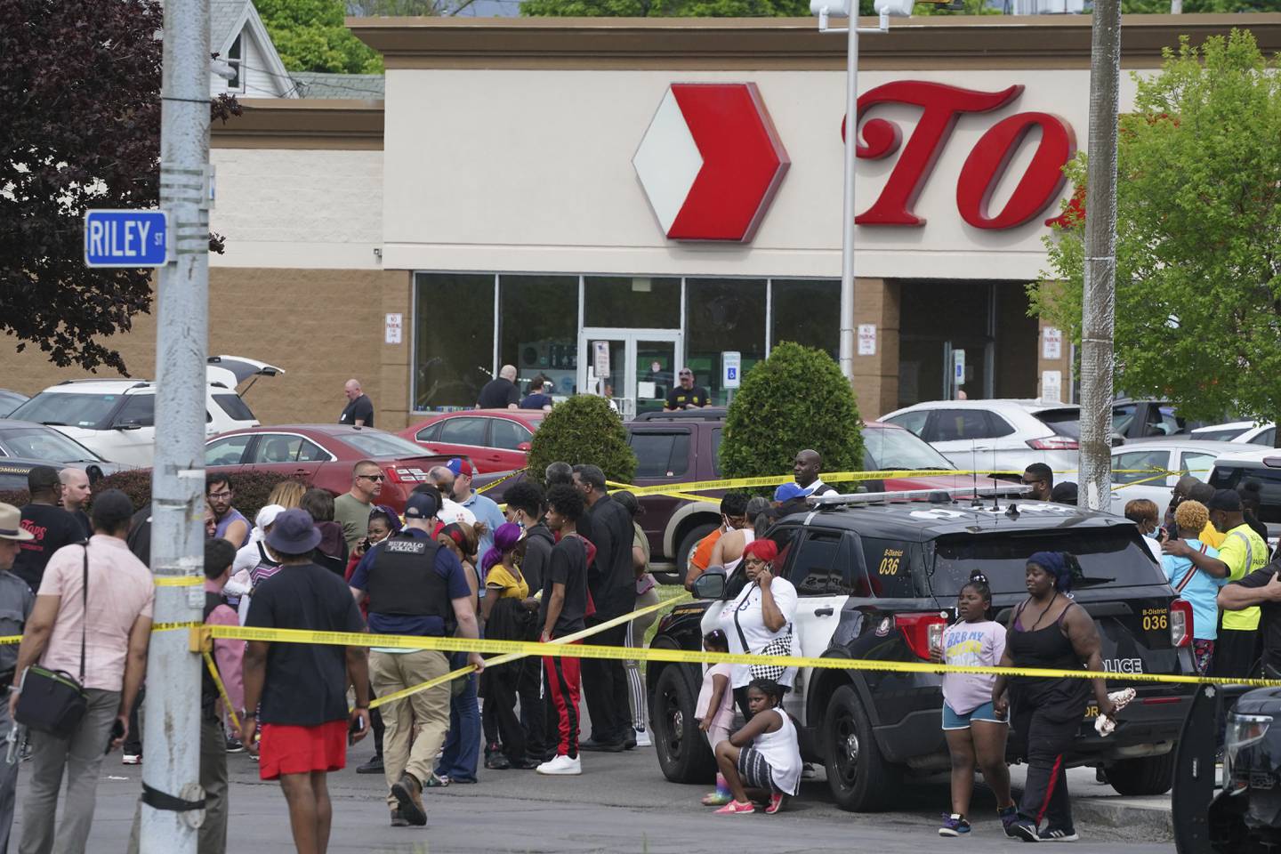 People gather outside a supermarket where several people were killed in a shooting, Saturday, May 14, 2022 in Buffalo, N.Y. Officials said the gunman entered the supermarket with a rifle and opened fire. Investigators believe the man may have been livestreaming the shooting and were looking into whether he had posted a manifesto online (Derek Gee/The Buffalo News via AP)