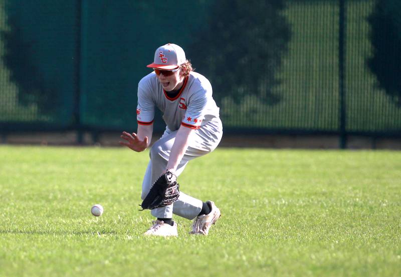 St. Charles East's Andrew Zolna scoops up a ground ball in right field during a game against Wheaton North on Wednesday, April 23, 2025 in St. Charles.