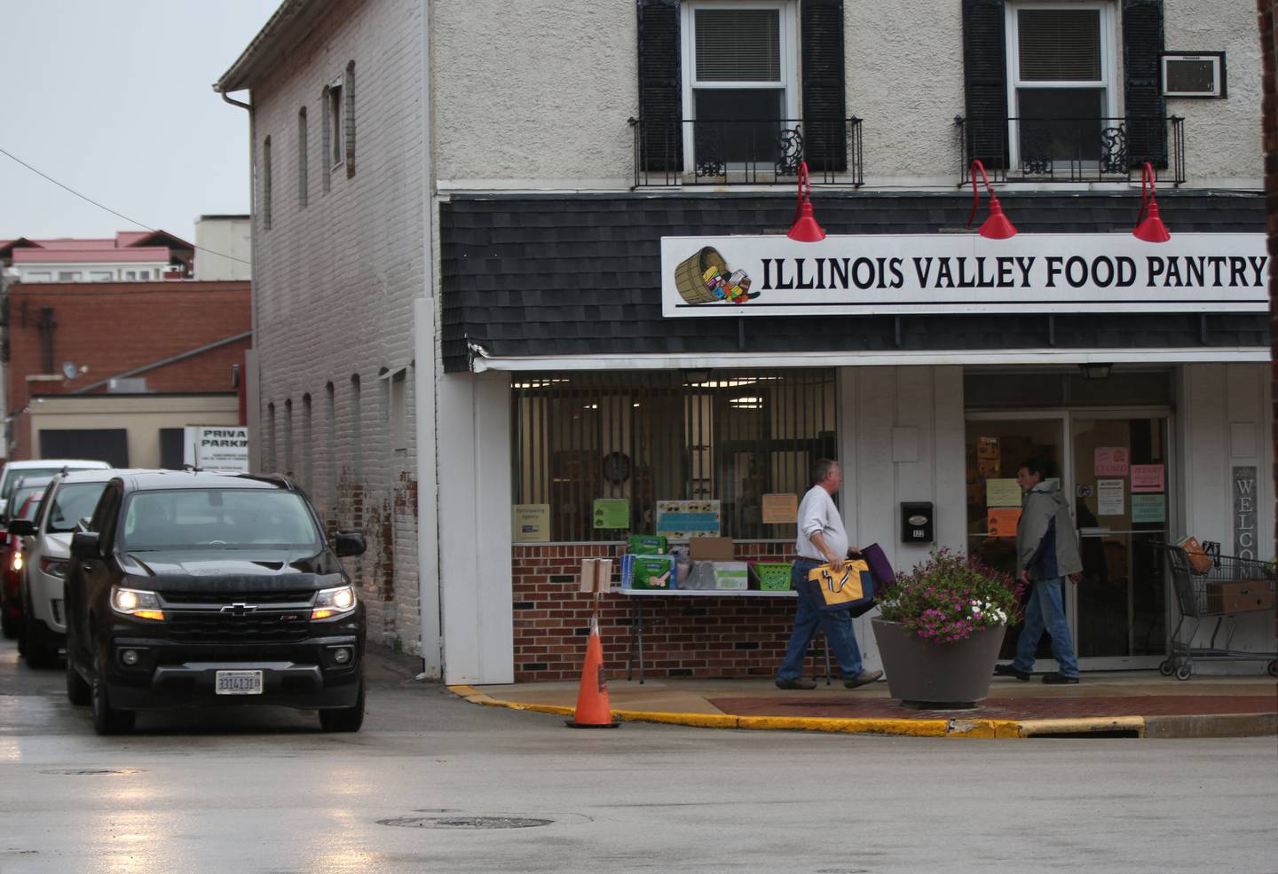 Volunteers work to bring out food while a long line of vehicles wait for food distribution on Wednesday, Oct. 11, 2023 at the Illinois Valley Food Pantry in La Salle.