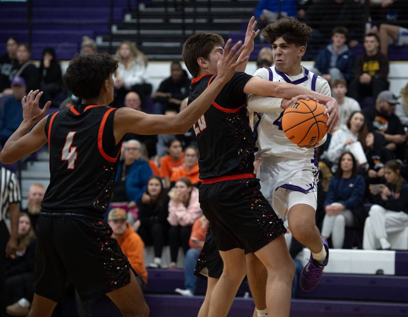 Manteno's Cade Bechard, right, looks for an open teammate as Beecher's Brian Oldenburg, center, and Wences Baumgartner, left, defend in the Thanksgiving tournament at Manteno High School on Monday, November 24, 2025.