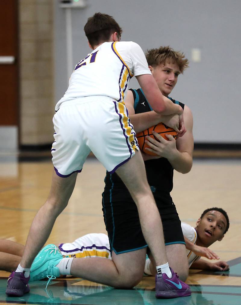 Woodstock North's Lincoln Buening ties up Hononegah’s Jace Brady as Hononegah's Caleb Hart looks up during the 2025 Hoops for Healing tournament basketball game on Wednesday, Nov. 26, 2025, at Woodstock North High School.