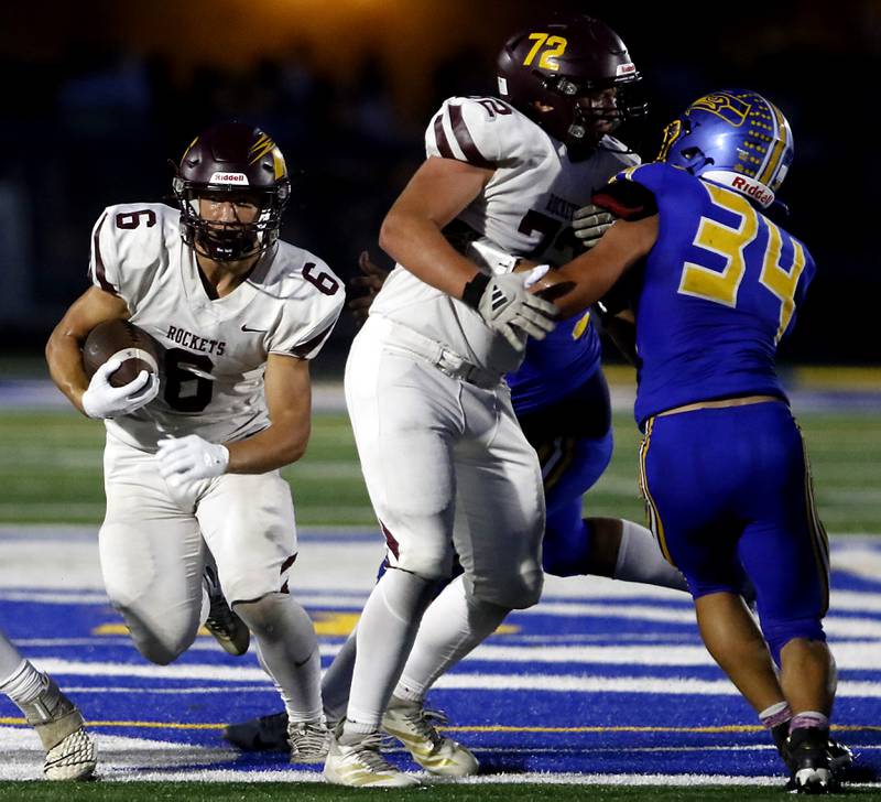 Richmond-Burton's Hunter Carley runs behind the block of his teammate, Shane Falasca, against Johnsburg's Duke Mays during a Kishwaukee River Conference football game on Friday, Sept. 12, 2025, at Johnsburg High School.
