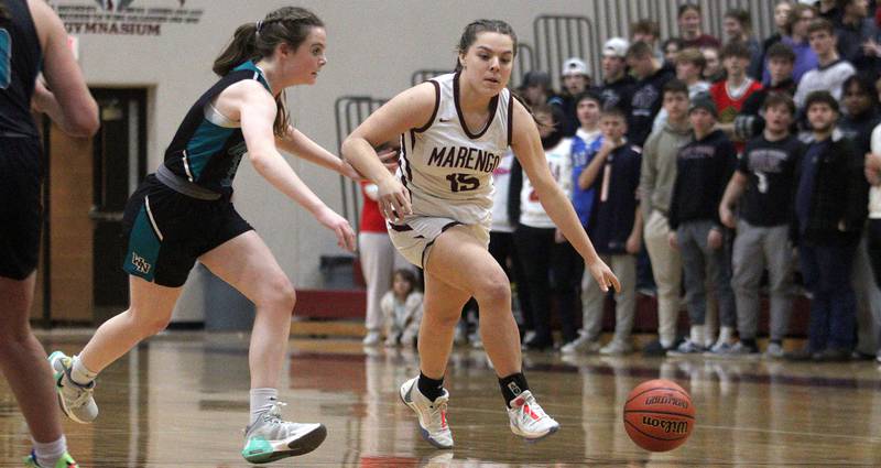 Marengo’s Emilie Polizzi, right, moves the ball past Woodstock North’s Adelyn Crabill in varsity girls basketball at Marengo Tuesday evening.