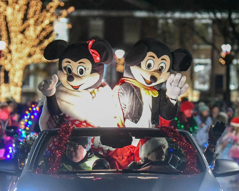 Micky and Minnie Mouse wave to community members during the Wheaton Holiday Parade held in downtown Wheaton on Friday Nov. 24, 2023.