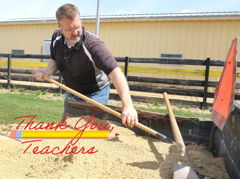 Mark Ekstrom, director of buildings and grounds for Sycamore Community School District 427, rakes dirt into low spots Tuesday, April 11, 2023, in the batting cage behind the softball field at Sycamore High School.
