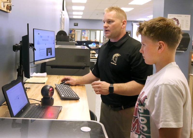 Kevin Boltz, career and technical education teacher at Sycamore Middle School, talks Friday, April, 11, 2025, to sixth grader Lincoln Rissman about the laser cutter in the STEM classroom at the school.
