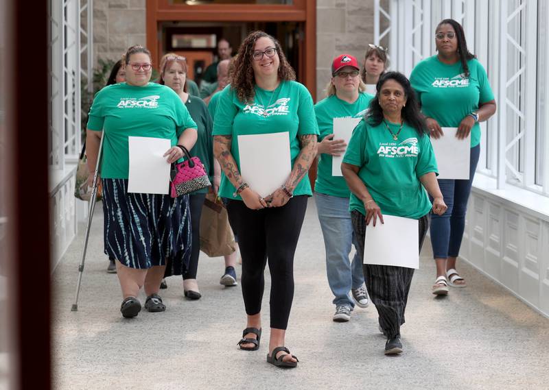 Northern Illinois University clerical, professional and administrative workers represented by the American Federation of State, County and Municipal Employees Local 1890 enter the board room Thursday, June 12, 2025, for the NIU Board of Trustees meeting in Altgeld Hall at NIU in DeKalb. Employees represented by AFSCME are asking for higher wages when their contract expires at the end of the month.