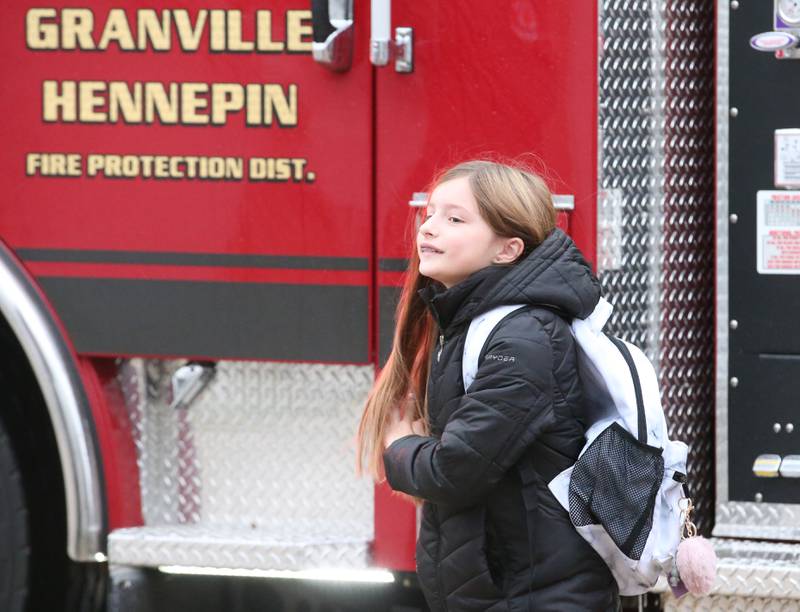 Putnam County Elementary student Giada Wright reacts after winning the Hennepin Fire Department Escape Floor plan contest as she is picked up on a fire engine and taken to school by deputy chief Quentin Buffington on Tuesday, Nov. 1, 2023. Students had to draw a floor plan or map of their home showing all doors and windows. Smoke alarms had to be marked in each plan. A family meeting place was also required to be marked on the drawings. The Hennepin Fire Department has been holding the contest for several years. The department stopped the event during Covid and continued it for the first time since the pandemic this year. The department picks the winning children up on a firetruck and busses them to school.