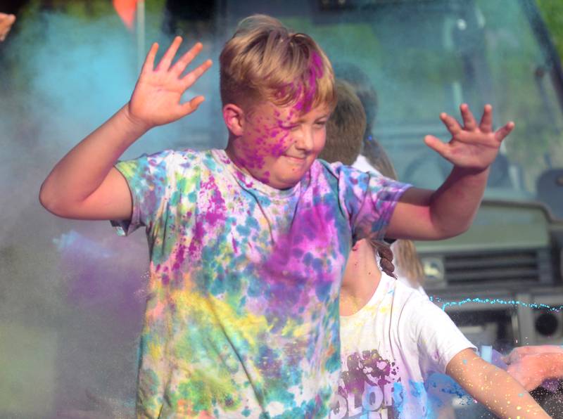 Stanley Voyles, 12, of Byron, raises his hands as he walks through a  powder station at the Oregon Park District's Color Run on Tuesday, July 22, 2025 at Oregon Park West.