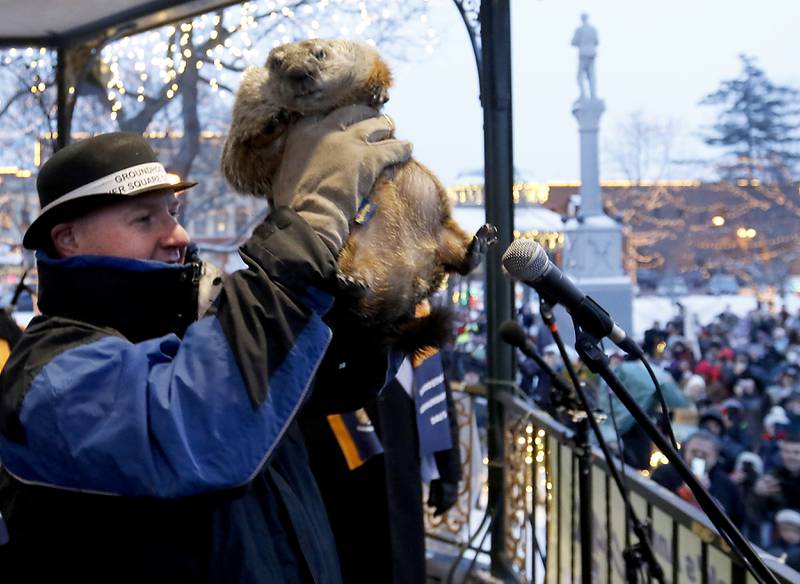 Woodstock Willie is held up by handler Mark Szafarn Wednesday, Feb, 2, 2022, during the annual Groundhog Day Prognostication on the Woodstock Square. This is the 30th anniversary of when the movie “Groundhogs Day” was filmed in Woodstock.