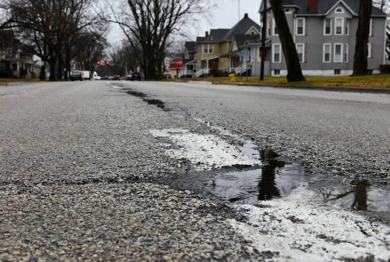 Rain puddles in the potholes along South Indiana Avenue in Kankakee in January 2023.