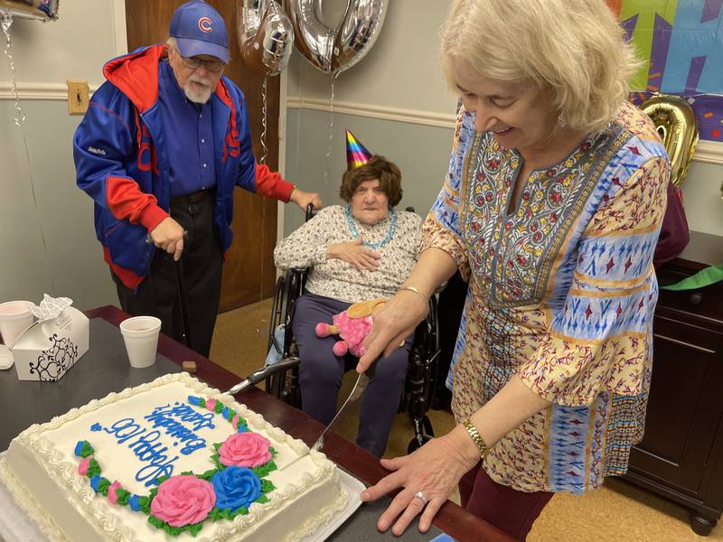 Nancy Hayes cuts the cake for her aunt, Sylvia Klosowski, who celebrated her 105th birthday Friday, March 18 at her home, Alden Terrace in McHenry. Also pictured is Klosowski's nephew, Richard.