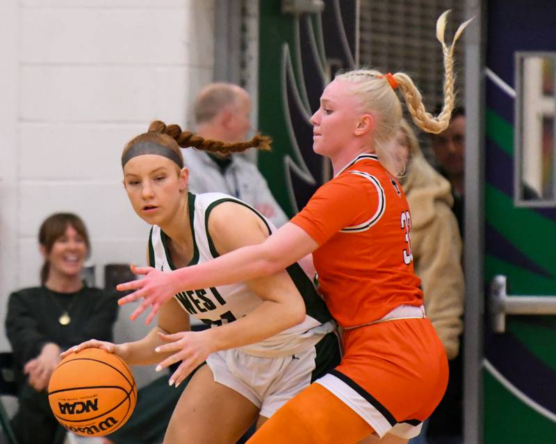 Glenbard West's Sophia Evans (24) tries to get around St. Charles East defender Addison Schilb (33) during the 4A Sectional championship game on Thursday Feb. 26, 2026, held at Bartlett High School.