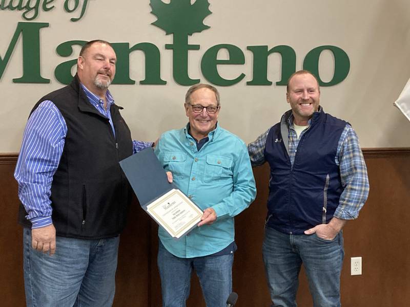 Dan Johnson, center, accepts a certificate from the village after his retirement from the public works department on Monday, Feb. 3, 2025. At left is Joel Gesky, village trustee, and Jim Hanley, superintendent of public works, on the right.