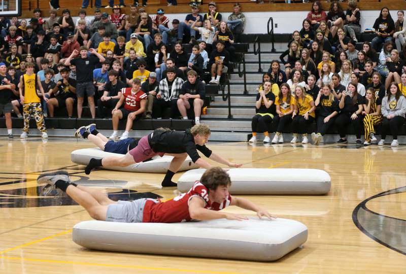 Putnam County High School students Dan Siegmann and Jonathan Stunkel belly flop on air matresses during a race at the football Homecoming Pep Rally on Friday, Sept. 27, 2024 at Putnam County High School in Granville.