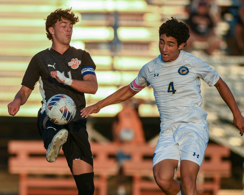 Wheaton Warrenville South's Leo Kise (11) tries to kick the ball away from Wheaton North's Michael Shebar (4) during the game on Thursday Sept. 11, 2025, held at Wheaton Warrenville South High School.