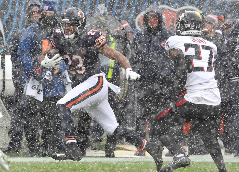 Chicago Bears running back Roschon Johnson runs through the heavy snow as Atlanta Falcons safety Richie Grant tries to make a play during their game Sunday, Dec. 31, 2023, at Soldier Field in Chicago.