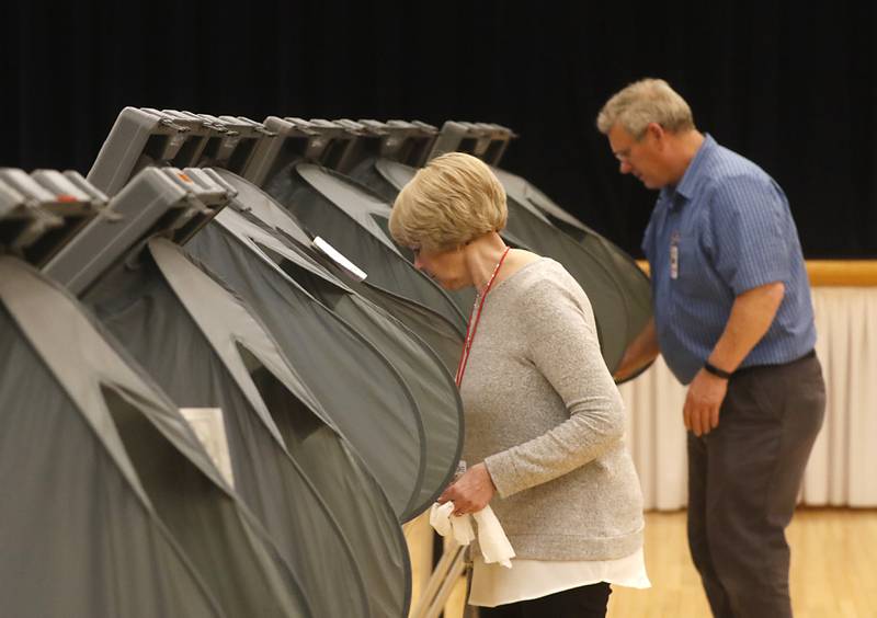 Election judges Sharon Lynch and Chris Brazas clean the voting machines between voters on Tuesday, April 4, 2023, during the 2023 consolidated election at Del Webb Sun City’s Prairie Lodge in Huntley.