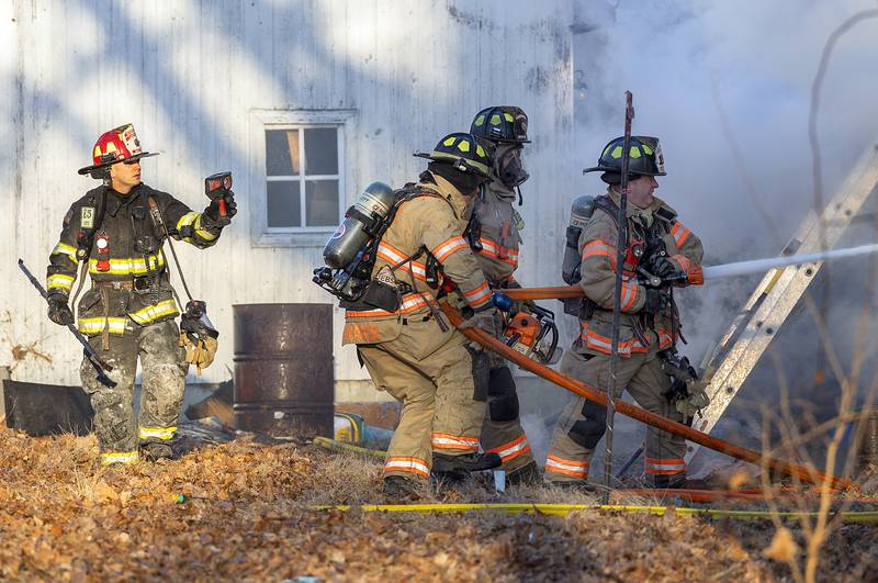 Firefighters pour water onto a fire Sunday, Jan. 19, 2025, at 550 Mill Street in Emerson.