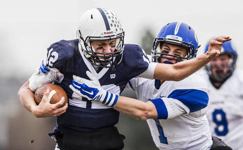 Cary-Grove quarterback Jason Gregoire attempts to escape a tackle from Geneva's Sean Chambers during the fourth quarter of Saturday's 7A quarterfinal in Cary.