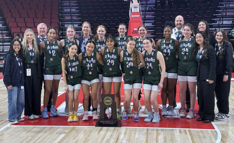 Members of the St. Edward girls basketball team pose with the Class 1A fourth place trophy on Friday, March 7, 2025 at CEFCU Arena in Normal.