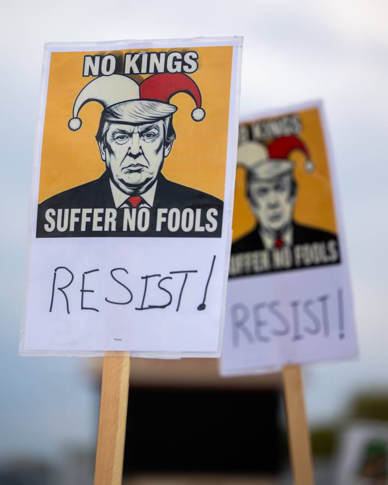 Protesters hold signs depicting Donald Trumps face at the ‘No Kings 2.0’ Protest on Saturday, October 18, 2025 on North Division Street in Morris