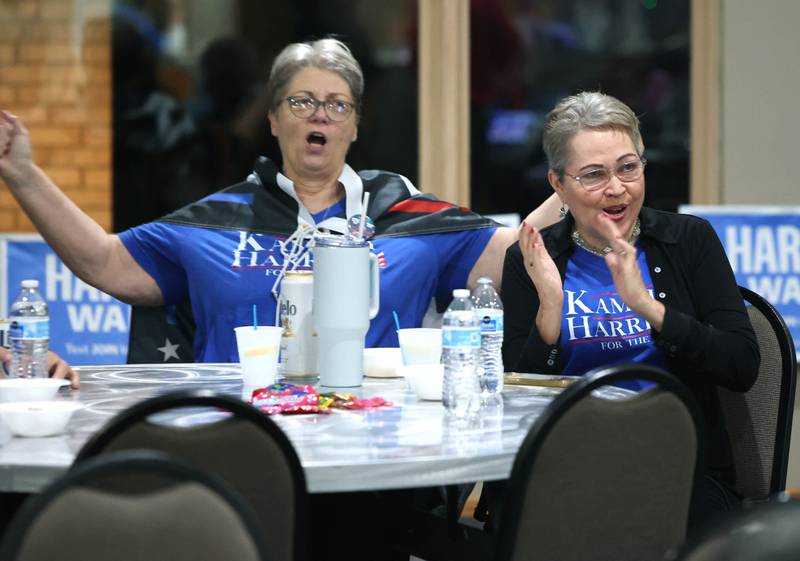 Ev Soltys (left) and Maria Ocasio, from DeKalb applaud as they watch election returns come in on a television Tuesday, Nov. 5, 2024, at the democratic election night watch party at River Heights Golf Club in DeKalb.