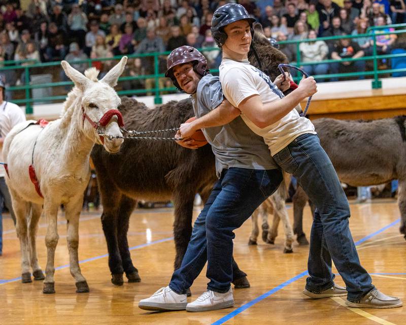 Member of the 'Village Church' team holds ball as Joey Arnold boxes him out during game of Donkey Basketball on Saturday, Feb. 7, 2026 at Seneca High School West Campus in Seneca.