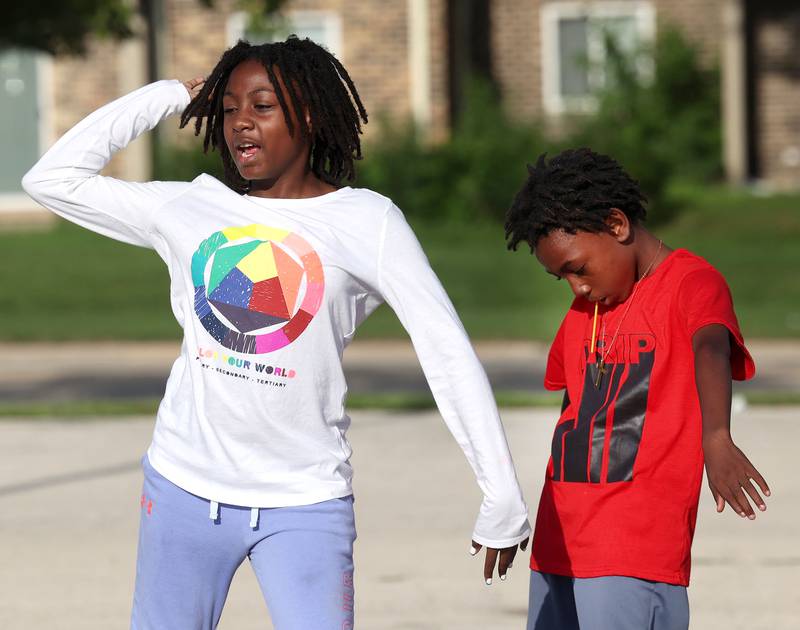 Chimaya Boss-Hall, 11, and her brother Kaylen, 10, from Joliet dance to the music Friday, July 18, 2025, during the DeKalb Peace Walk and Rally. The event, which featured a march, food vendors and music, was held to encourage the community to work together against gun violence.