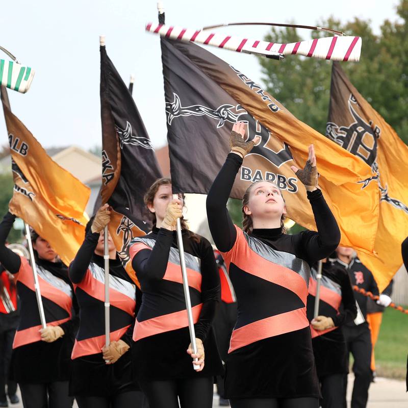 Members of the DeKalb High School flag team march down Dresser Road Wednesday, Sept. 27, 2023, during the homecoming parade.
