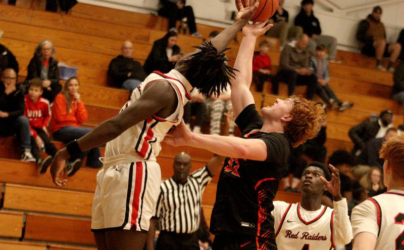 Crystal Lake Central’s Rhett Ozment, right, battles Huntley’s Sheldon Bonsu, left, during tournament basketball action at Johnsburg High School Monday evening.