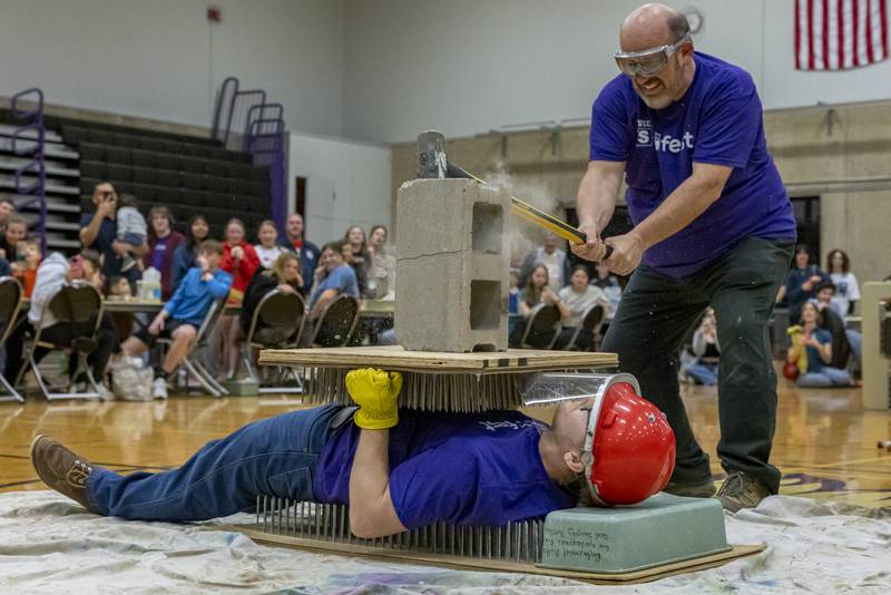 Illinois Valley Community College Instructor Matthew Johll, smashes a cinderblock over the chest of Ryan Schulz, who volunteered to lay between the bed of nails for the demonstration at SciFest on April 11, 2025 at Illinois Valley Community College.