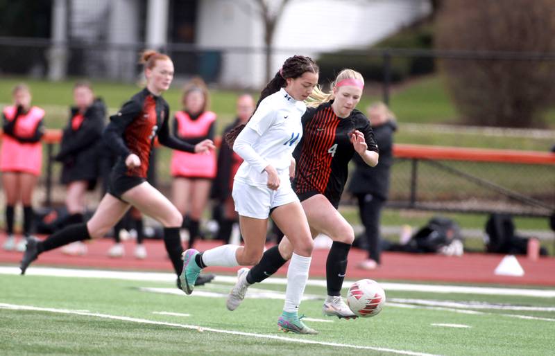 Burlington Central’s Sydney Batts (left) and St. Charles East’s Presley Kannaka go after the ball during a game on Tuesday, April 1, 2025 in St. Charles.