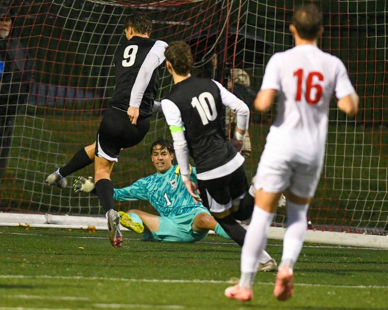 Prairie Ridge's Henry Knoll (9) scores a goal off a rebound from Benet Academy's goalkeeper Patrick Stasch (1) during the class 2A super sectional soccer match on Tuesday Nov. 5, 2024, held at Wheaton Academy in West Chicago.