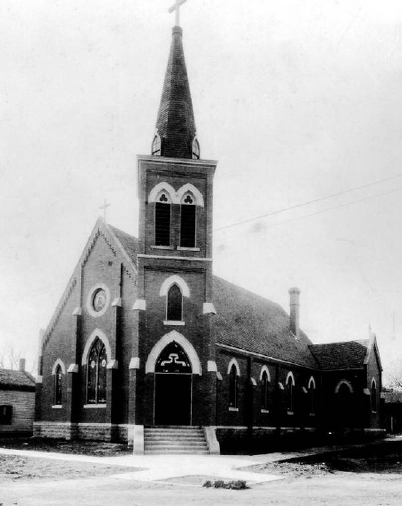 This photo of the new church was taken at the time of its dedication in January, 1900. While sidewalks are in place, the streets have yet to be paved. The steeple would later be removed. To the south (left) is the Chapman house which would be later purchased and moved to make room to build the new rectory.