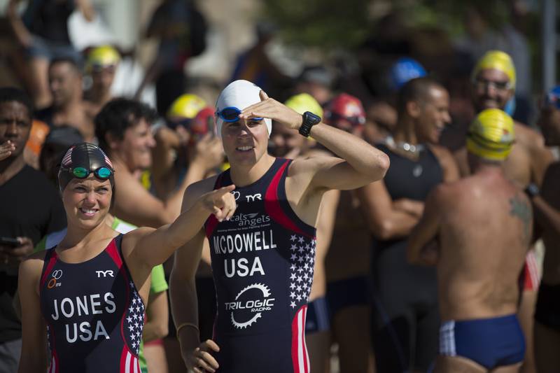 Triathlon athletes Erin Jones, left, and Kevin Mcdowell, of the U.S., lead a swimming clinic for local swimmers along Copacabana beach in Rio de Janeiro, Brazil, Monday, Aug. 3, 2015.