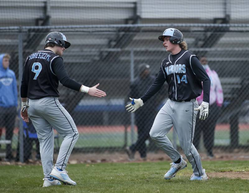 Willowbrook’s Isaac Sobieszczyk (9) and Jacob Kutella (14) celebrate after scoring runs against Downers Grove South during a game in Downers Grove on Tuesday, April 5, 2022.