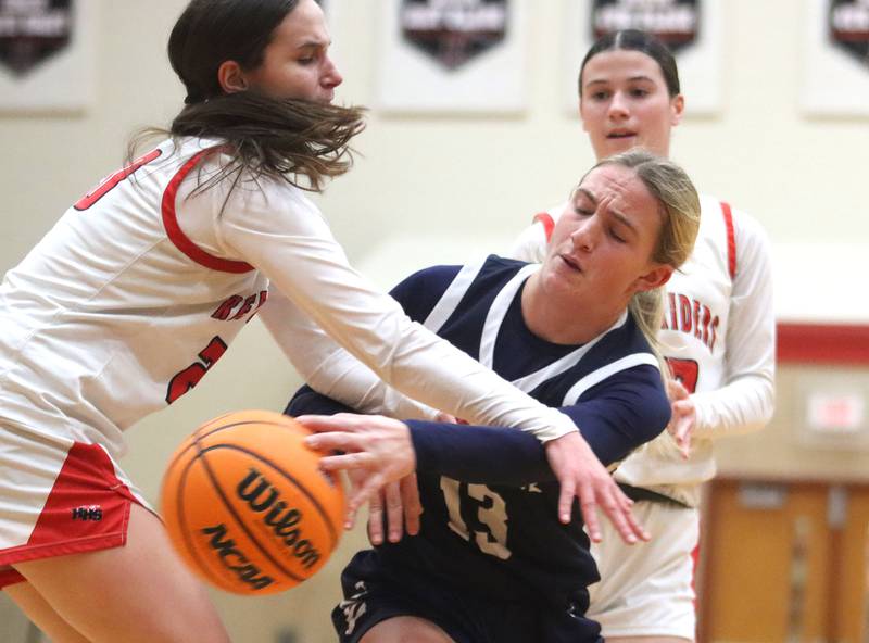 Cary-Grove’s Malaina Kurth, right, flings the ball past Huntley’s Alyssa Borzych, left, in varsity girls basketball on Monday, Feb. 2, 2026, at Huntley High School in Huntley.