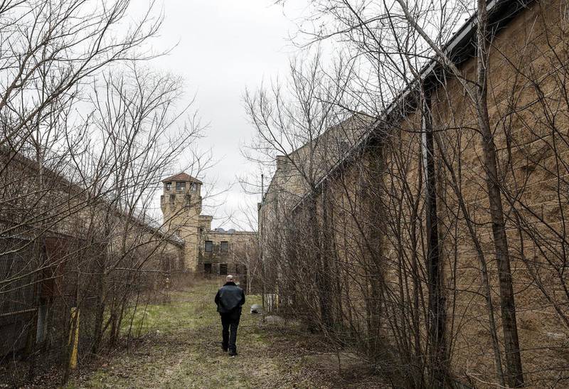 Officer John Struna walks between buildings March 28 at the Collins Street prison complex in Joliet.