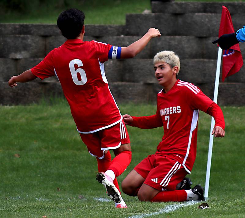 Dundee-Crown’s Hugo Arista, right, falls to his knees and is greeted by Moises Rodriguez, left, after an Arista goal against St. Charles East in IHSA Class 3A Regional Championship soccer at Dundee-Crown High School in Carpentersville on Saturday, October 25, 2025.